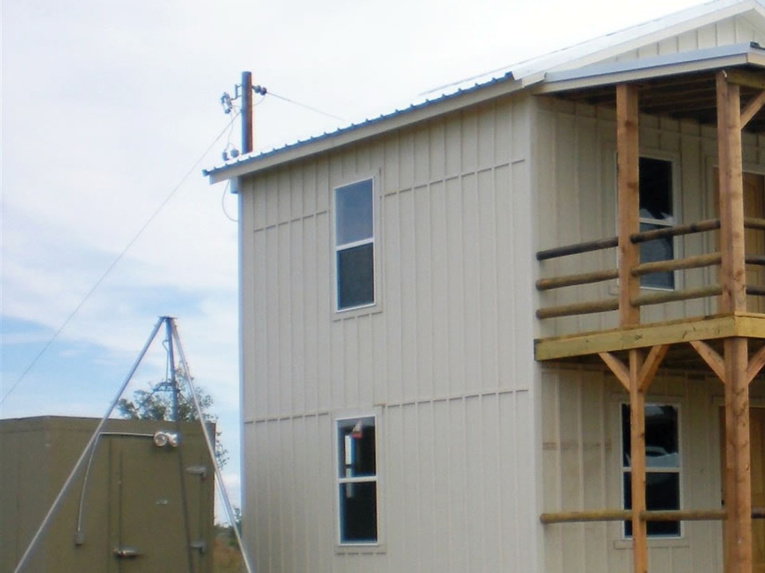 small garden tool shed with wood siding and a peaked roof in a yard