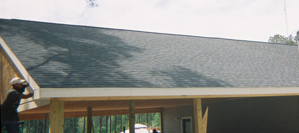 large covered porch and garage addition framed with wood posts
