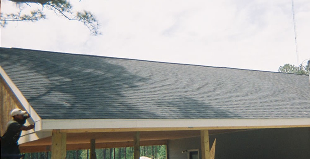 large covered porch and garage addition framed with wood posts